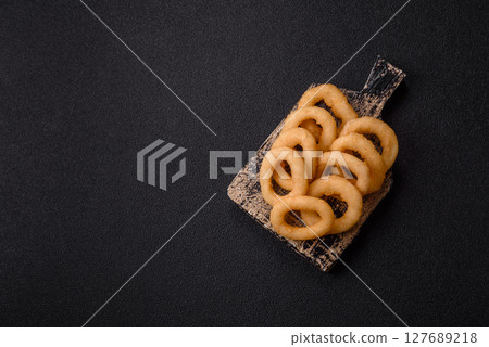 Onion rings or squid rings fries crispy, savory with sauce 127689218