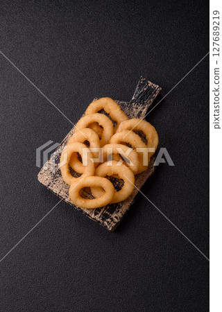 Onion rings or squid rings fries crispy, savory with sauce Onion rings or squid rings fries crispy, savory with sauce 127689219