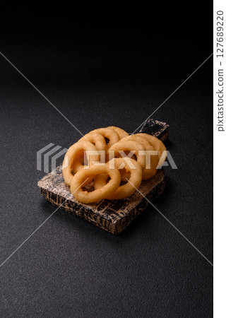 Onion rings or squid rings fries crispy, savory with sauce 127689220