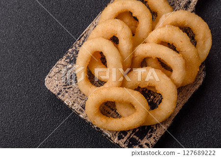 Onion rings or squid rings fries crispy, savory with sauce 127689222