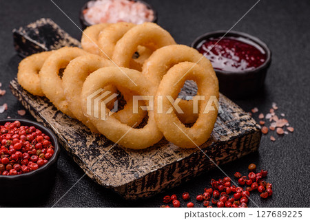 Onion rings or squid rings fries crispy, savory with sauce 127689225