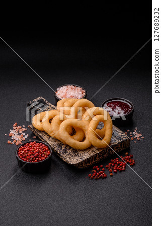 Onion rings or squid rings fries crispy, savory with sauce 127689232