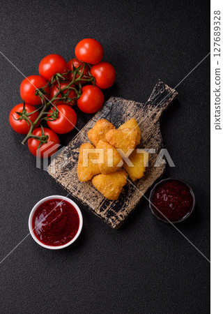 Fried mozzarella or brie cheese with cranberry or raspberry sauce 127689328