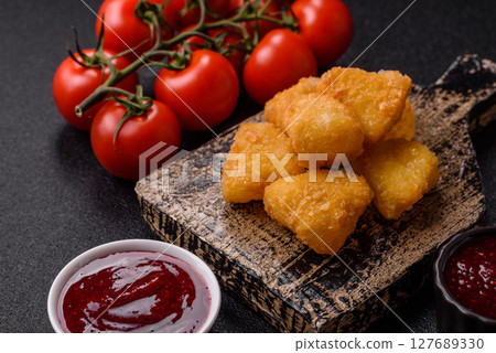 Fried mozzarella or brie cheese with cranberry or raspberry sauce 127689330