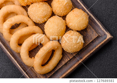 Food, chicken nuggets, onion rings and cheese balls on dark background 127689381