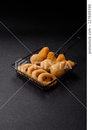 Food, chicken nuggets, onion rings and cheese balls on dark background Food, chicken nuggets, onion rings and cheese balls on dark background 127689390