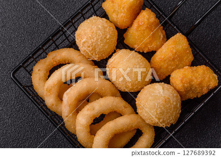 Food, chicken nuggets, onion rings and cheese balls on dark background 127689392