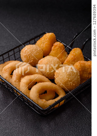 Food, chicken nuggets, onion rings and cheese balls on dark background 127689394