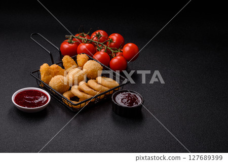 Food, chicken nuggets, onion rings and cheese balls on dark background Food, chicken nuggets, onion rings and cheese balls on dark background 127689399