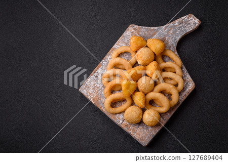 Food, chicken nuggets, onion rings and cheese balls on dark background Food, chicken nuggets, onion rings and cheese balls on dark background 127689404