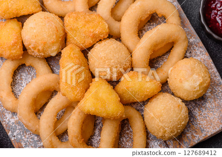 Food, chicken nuggets, onion rings and cheese balls on dark background 127689412