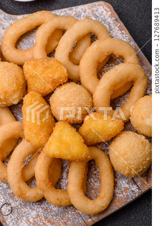 Food, chicken nuggets, onion rings and cheese balls on dark background Food, chicken nuggets, onion rings and cheese balls on dark background 127689413