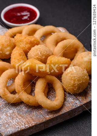 Food, chicken nuggets, onion rings and cheese balls on dark background Food, chicken nuggets, onion rings and cheese balls on dark background 127689414