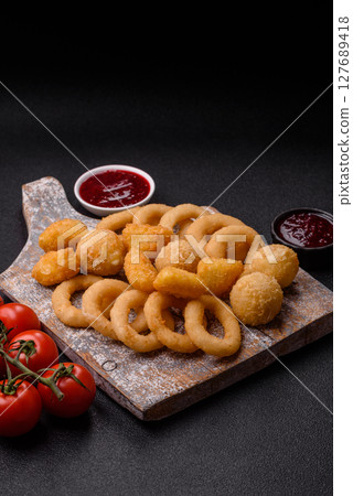 Food, chicken nuggets, onion rings and cheese balls on dark background 127689418