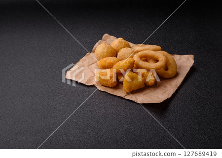 Food, chicken nuggets, onion rings and cheese balls on dark background Food, chicken nuggets, onion rings and cheese balls on dark background 127689419