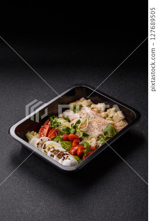 Bowl with caesar salad with chicken, parmesan cheese, tomatoes, croutons, lettuce leaves Bowl with caesar salad with chicken, parmesan cheese, tomatoes, croutons, lettuce leaves 127689505