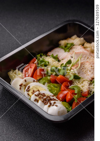 Bowl with caesar salad with chicken, parmesan cheese, tomatoes, croutons, lettuce leaves Bowl with caesar salad with chicken, parmesan cheese, tomatoes, croutons, lettuce leaves 127689509