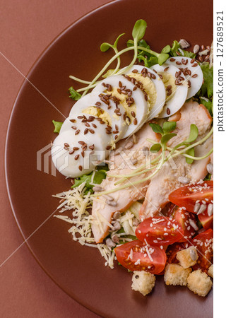 Bowl with caesar salad with chicken, parmesan cheese, tomatoes, croutons, lettuce leaves 127689521