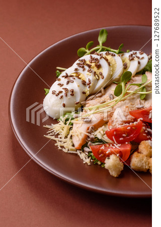Bowl with caesar salad with chicken, parmesan cheese, tomatoes, croutons, lettuce leaves Bowl with caesar salad with chicken, parmesan cheese, tomatoes, croutons, lettuce leaves 127689522