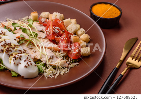 Bowl with caesar salad with chicken, parmesan cheese, tomatoes, croutons, lettuce leaves Bowl with caesar salad with chicken, parmesan cheese, tomatoes, croutons, lettuce leaves 127689523