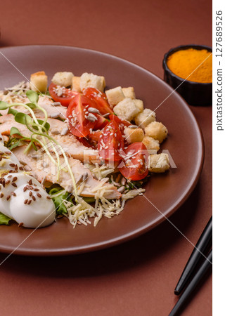 Bowl with caesar salad with chicken, parmesan cheese, tomatoes, croutons, lettuce leaves 127689526