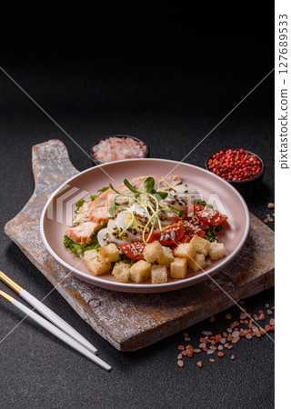 Bowl with caesar salad with chicken, parmesan cheese, tomatoes, croutons, lettuce leaves Bowl with caesar salad with chicken, parmesan cheese, tomatoes, croutons, lettuce leaves 127689533