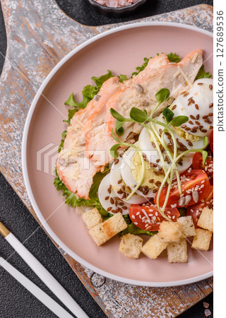 Bowl with caesar salad with chicken, parmesan cheese, tomatoes, croutons, lettuce leaves Bowl with caesar salad with chicken, parmesan cheese, tomatoes, croutons, lettuce leaves 127689536