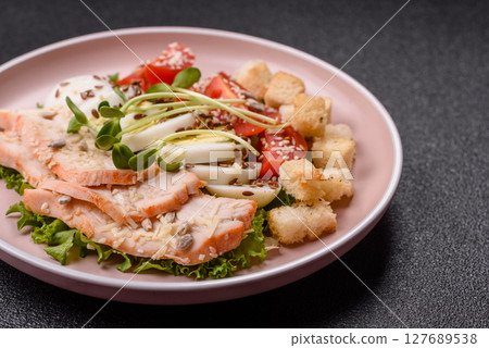 Bowl with caesar salad with chicken, parmesan cheese, tomatoes, croutons, lettuce leaves Bowl with caesar salad with chicken, parmesan cheese, tomatoes, croutons, lettuce leaves 127689538