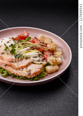 Bowl with caesar salad with chicken, parmesan cheese, tomatoes, croutons, lettuce leaves 127689541