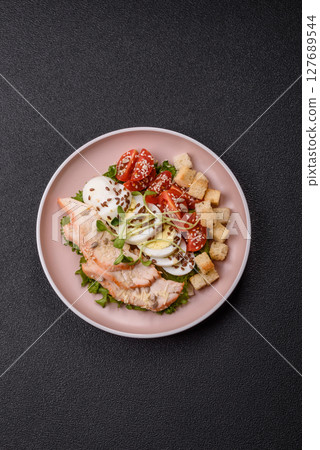 Bowl with caesar salad with chicken, parmesan cheese, tomatoes, croutons, lettuce leaves 127689544