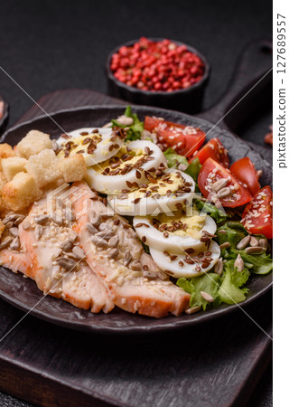 Bowl with caesar salad with chicken, parmesan cheese, tomatoes, croutons, lettuce leaves 127689557