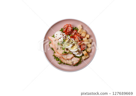 Bowl with caesar salad with chicken, parmesan cheese, tomatoes, croutons, lettuce leaves 127689669