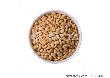 Peeled pine nuts in a bowl on a white background 127689738