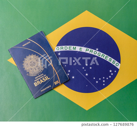 Brazilian passport against the background of the national flag of Brazil 127689876