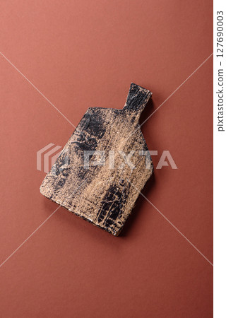 Empty wooden cutting board on a monochrome brown background 127690003