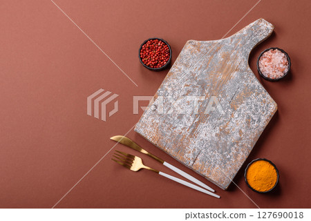 Empty wooden cutting board on a monochrome brown background Empty wooden cutting board on a monochrome brown background 127690018