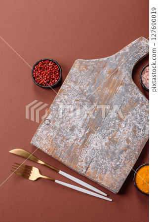 Empty wooden cutting board on a monochrome brown background Empty wooden cutting board on a monochrome brown background 127690019