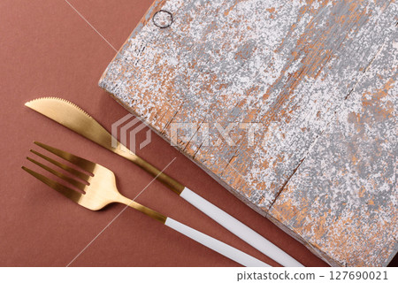 Empty wooden cutting board on a monochrome brown background 127690021