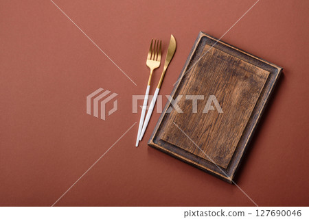 Empty wooden cutting board on a monochrome brown background Empty wooden cutting board on a monochrome brown background 127690046