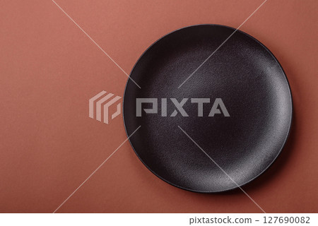 Empty ceramic plate on a monochrome brown background Empty ceramic plate on a monochrome brown background 127690082