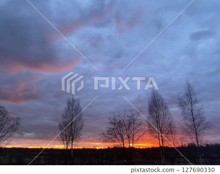 A breathtaking and stunning sunset casts its vibrant glow over a tranquil and serene landscape 127690330