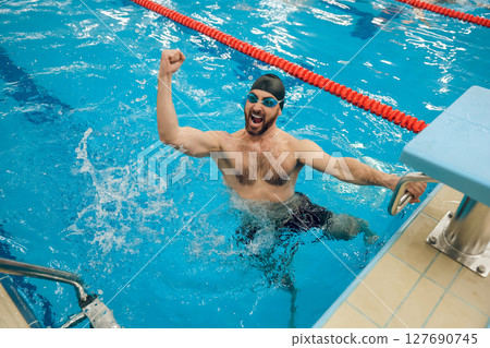 Man in swimming pool feeling excited and happy 127690745