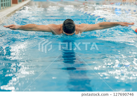 Man having a workout in the swimming pool 127690746