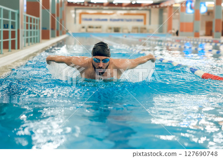 Man having a workout in the swimming pool Man having a workout in the swimming pool 127690748