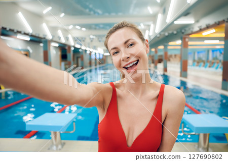 Pretty fit young woman in red swimsuit in the pool Pretty fit young woman in red swimsuit in the pool 127690802