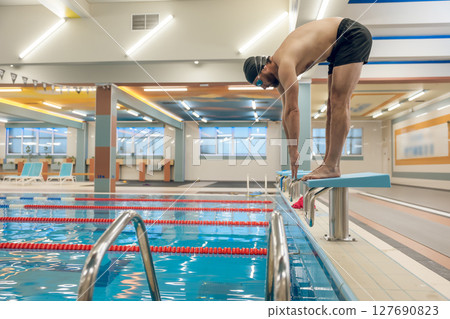 Man having a workout in the swimming pool 127690823