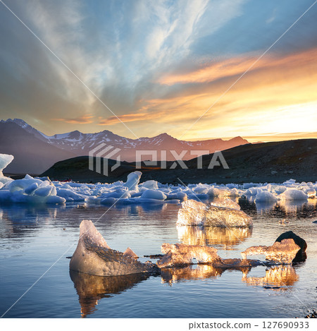 Ramarkable landscape with floating icebergs in Jokulsarlon glacier lagoon at sunset. 127690933