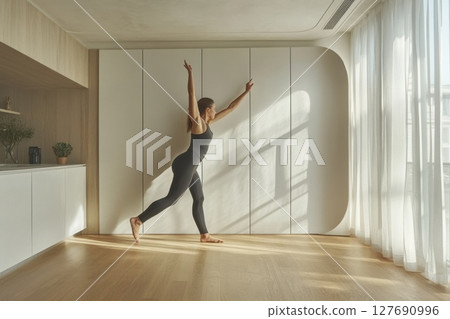 Practicing wall pilates in a well-lit, modern indoor space Practicing wall pilates in a well-lit, modern indoor space 127690996