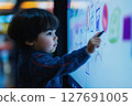 Child is creating colorful art on a touchscreen display with excitement 127691005
