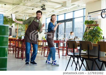 Man and woman waiters celebrating at restaurant 127691082